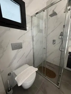 a bathroom with a shower and a toilet and a television at Caesar Resort & SPA & Apartments Spacious Studio in Avgorou
