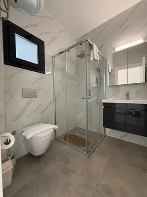 a bathroom with a shower and a toilet and a sink at Caesar Resort & SPA & Apartments Spacious Studio in Avgorou