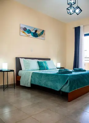 a bedroom with a large bed with blue sheets at Sunday's Apartment in Paralimni