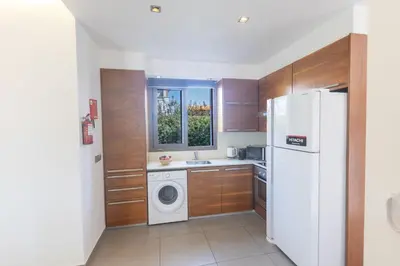 a kitchen with a white refrigerator and a washing machine at Ayia Napa Satin Villa SVI1 in Ayia Napa
