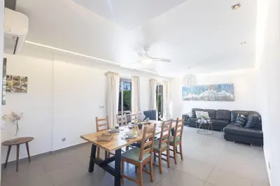 a dining room and living room with a table and chairs at Ayia Napa Satin Villa SVI1 in Ayia Napa
