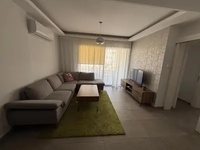 a living room with a couch and a tv at Mordern 2BD APT Perfect for Family or Group in Larnaka