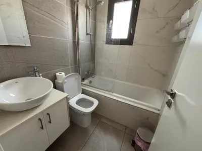 a bathroom with a sink and a toilet and a tub at Mordern 2BD APT Perfect for Family or Group in Larnaka