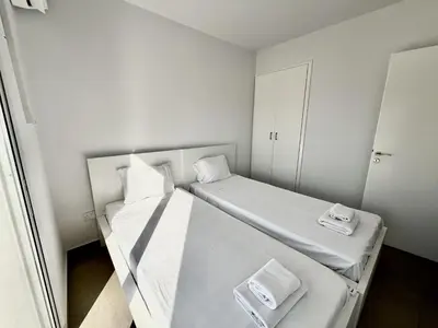 a small white room with two beds in it at STAY Ease Apartment in Ayia Napa
