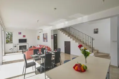 a living room and dining room with a table and chairs at Pearl Villas in Protaras