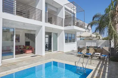 a villa with a swimming pool and a house at Pearl Villas in Protaras