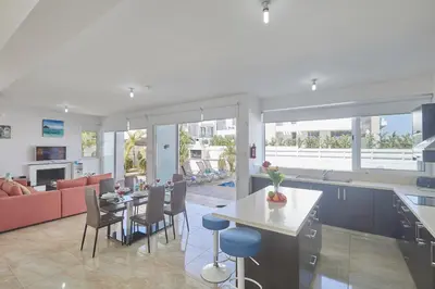a kitchen and living room with a table and chairs at Pearl Villas in Protaras