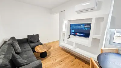 a living room with a couch and a tv at Larnaca Beach Bliss Apartment in Larnaka