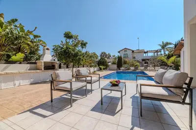 a patio with chairs and a swimming pool at Kymma River Villa #4 in Ayia Napa