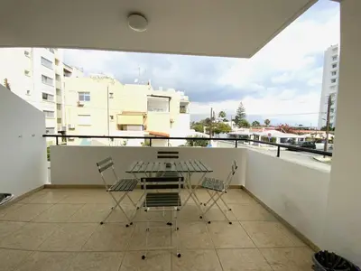 a patio with a table and chairs on a balcony at 2 Combined Apts, Fast Wi-Fi, 5 Min Walk to Beach in Larnaka