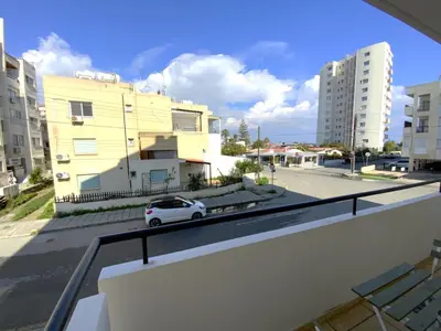 a white car parked on a city street with buildings at 2 Combined Apts, Fast Wi-Fi, 5 Min Walk to Beach in Larnaka
