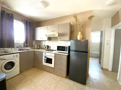 a kitchen with a refrigerator and a dishwasher at Spacious 3Apt Combo, Fast WiFi, 5Min Walk to Beach in Larnaka