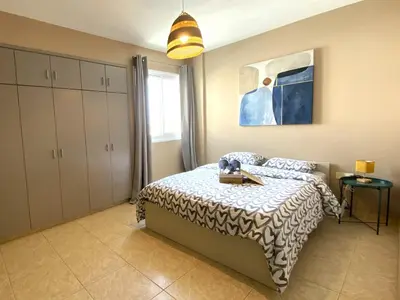 a bedroom with a bed with a table on it at Spacious 3Apt Combo, Fast WiFi, 5Min Walk to Beach in Larnaka