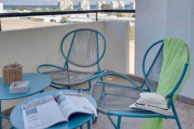 a table and chairs with an open book on a balcony at Charming 3-Bed Duplex with Stunning Sea View in Larnaka