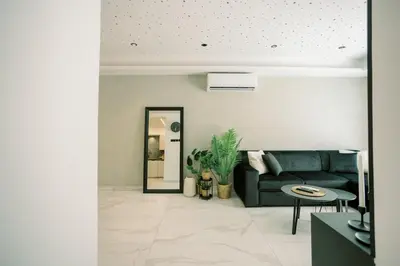a living room with a couch and a mirror at 2BR Amalfi Blue Apt in Larnaca - Pool & 10Min Walk to Mackenzie Beach! in Larnaka
