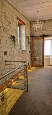 a large room with a stone wall and a chandelier at Vouno Vouni Cottage in Vouni