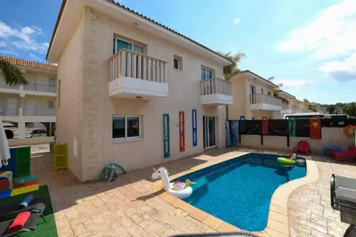 a house with a swimming pool and a house with a building at Chromata means colorful for a much-needed sunny escape, check your stay! in Protaras