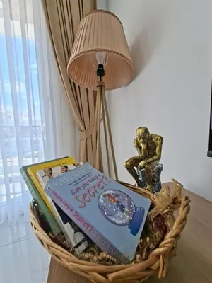 a basket with books and a lamp on a table at Spacious & Bright 2BR Apartment, 5min to Beach in Boğaz