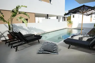 a patio with two chairs and a swimming pool at 4BR BrandNEW LUX Villa Protaras in Paralimni