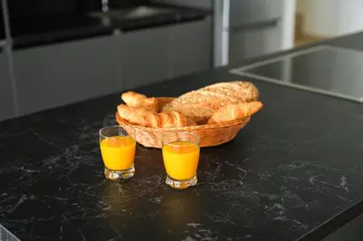 two glasses of orange juice next to a basket of bread at 4BR BrandNEW LUX Villa Protaras in Paralimni