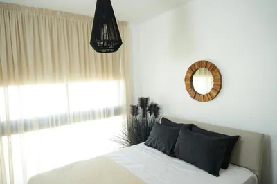 a bedroom with a bed and a mirror and a window at 4BR BrandNEW LUX Villa Protaras in Paralimni