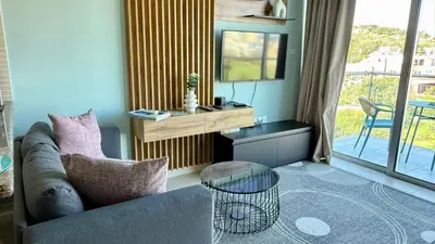 a living room with a couch and a table at Too Coool Studio Apartment Coralli Resort in Protaras