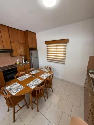 a kitchen with a table with chairs and a refrigerator at Makenzy Mermaid 2 Bedroom Apartment in Larnaka