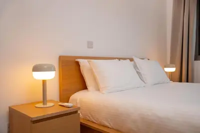 a bedroom with a bed and a lamp on a night stand at Crown Hall Suites in Limassol