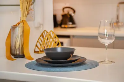 a black bowl on a plate next to a wine glass at Crown Hall Suites in Limassol