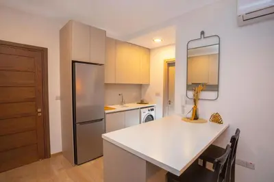 a kitchen with a white counter and a refrigerator at Crown Hall Suites in Limassol