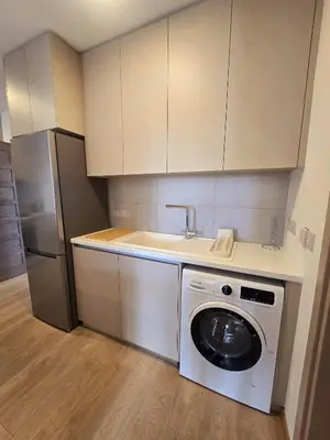 a kitchen with a washing machine and a refrigerator at Crown Hall Suites in Limassol