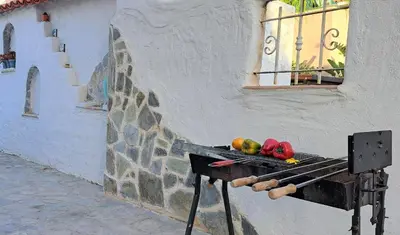 a grill with fruits and vegetables on it next to a building at Landina villa in Protaras