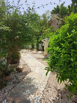 a garden with a statue of a goat on a walkway at Landina villa in Protaras