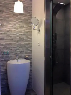 a bathroom with a white sink and a shower at Advice Deluxe in Nicosia