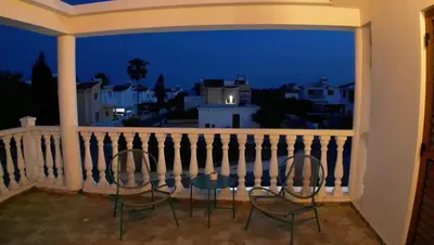 two chairs sitting on a balcony at night at Celestial Villa in Ayia Napa