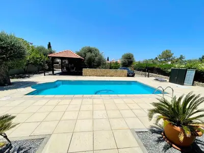 a swimming pool in a yard with a gazebo at Cheerful and cozy Bungalow with pool and fireplace in Athalassa