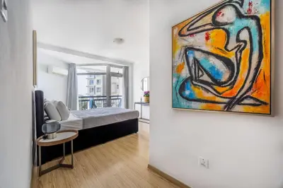 a room with a bed and a painting on the wall at Marathon Beach Apartment - Sea View, Shared Pool in Limassol