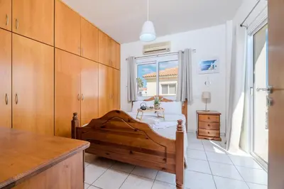 a bedroom with a wooden bed and a window at Marika Heights in Ayia Napa