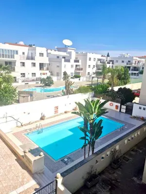 a view of a swimming pool with buildings in the background at Charming Oroklini Penthouse with Ocean Views and Private Parking in Voroklini