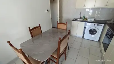 a kitchen with a table and a washing machine at Emiliano 7 Holiday Apartment in Larnaka