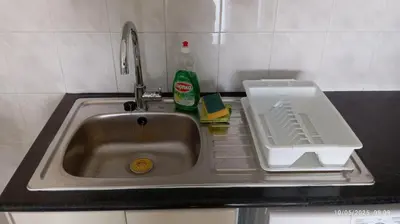 a kitchen sink with a dish drying rack next to it at Emiliano 7 Holiday Apartment in Larnaka