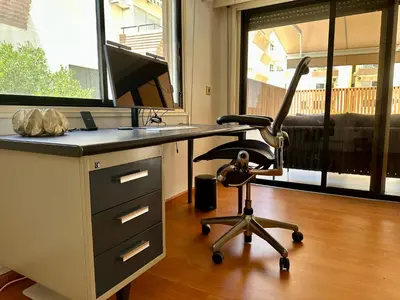an office with a desk with a chair and a window at Beachfront apartment with Kids Room, Pool & 2 Workspaces in Limassol