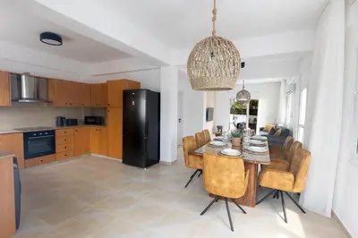 a kitchen and dining room with a table and chairs at EvelMar Villa in Protaras