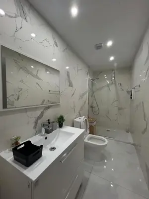 a white bathroom with a sink and a toilet at Sia-Serenity Finikoudes Apartment in Larnaka