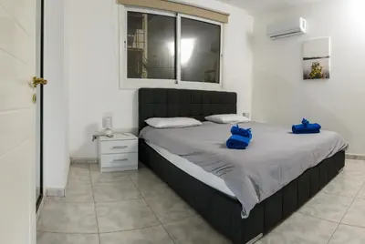 a bedroom with a bed with blue bags on it at Ariel 3 bed Apartment in Larnaka