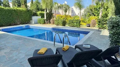 a pool with chairs next to a swimming pool at Too Coool Villa Milos Lifestyle in Protaras