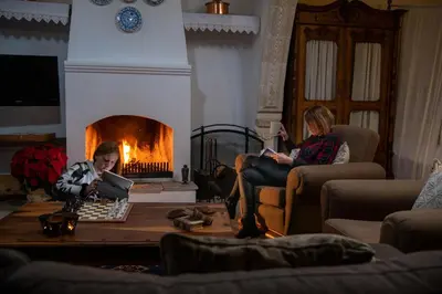 a group of people sitting in a living room with a fireplace at Apanemia Inn House in Lofou