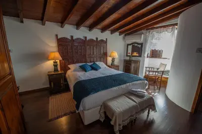 a bedroom with a large bed with blue pillows at Apanemia Inn House in Lofou
