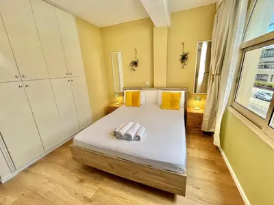 a bedroom with a bed with yellow walls and a window at Tropical Cozy 1 - Bedroom Apartment in Limassol