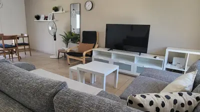 a living room with a couch and a flat screen tv at HANA Holiday house in Ayia Napa